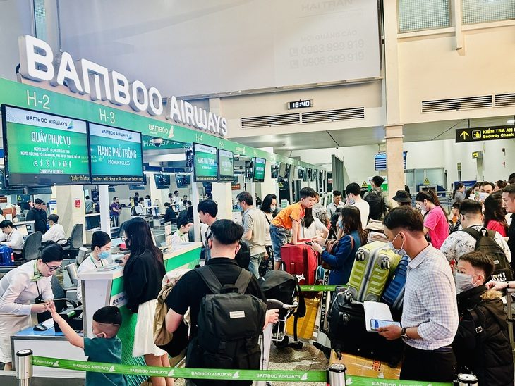 Bamboo Airways chuyển trụ sở chính vào TP.HCM, trong khuôn viên sân golf Tân Sơn Nhất- Ảnh 1. Bamboo Airways sử dụng một phần nhân lực dôi dư do giảm quy mô tàu bay là các tiếp viên hàng không để làm thủ tục check-in tại Tân Sơn Nhất - Ảnh: CÔNG TRUNG