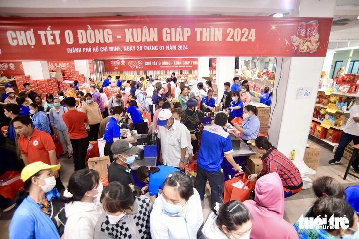 2.000 gia đình rộn ràng đi chợ Tết 0 đồng- Ảnh 1. Chợ Tết 0 đồng được tổ chức tại TP.HCM. Đại diện mỗi hộ gia đình sẽ nhận phiếu mua hàng của siêu thị Co.opmart trị giá 600.000 đồng để lựa chọn nhu yếu phẩm được cung cấp tại địa điểm của sự kiện cho bữa cơm Tết.