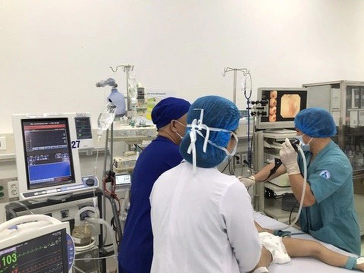 Ba anh em ruột bị ngạt khói đã khỏe hơn, bé út xuất viện- Ảnh 1. Các bác sĩ nội soi cấp cứu cho một trong ba anh em ruột bị ngạt khói - Ảnh: Bệnh viện cung cấp